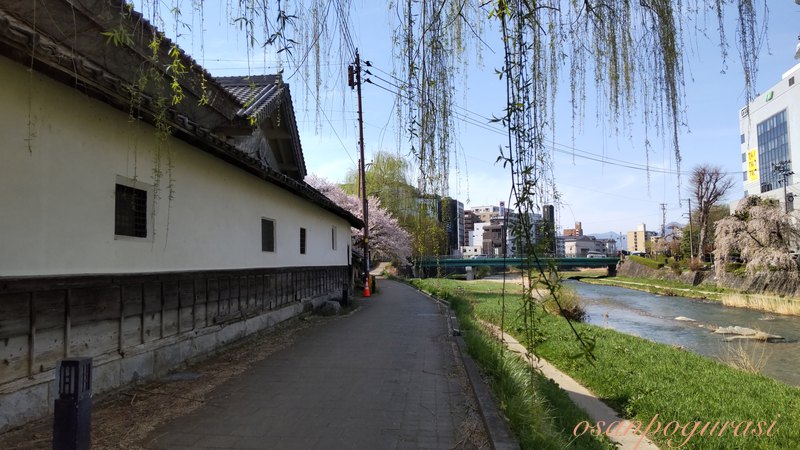 ござ九商店の白い土塀と中津川沿いの道